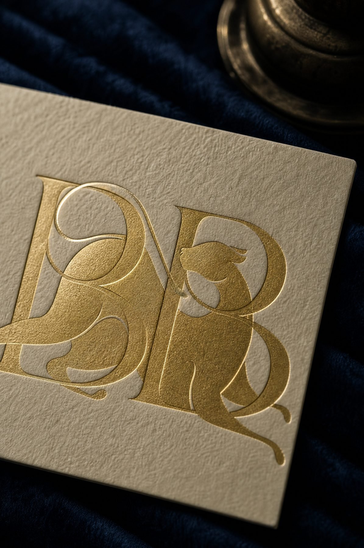 The BB monogram in gold foil on ivory stock.
